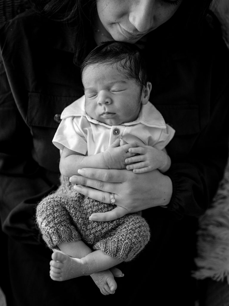Sleeping newborn baby in Mum's arms during a newborn photography session in Perth