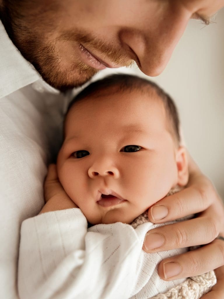 Awake newborn baby being held by Dad during a newborn photography session in Perth