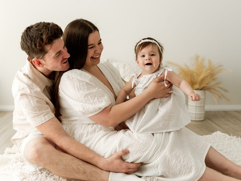 Mum and Dad cuddling their one-year-old during a family portrait at Four O Photography